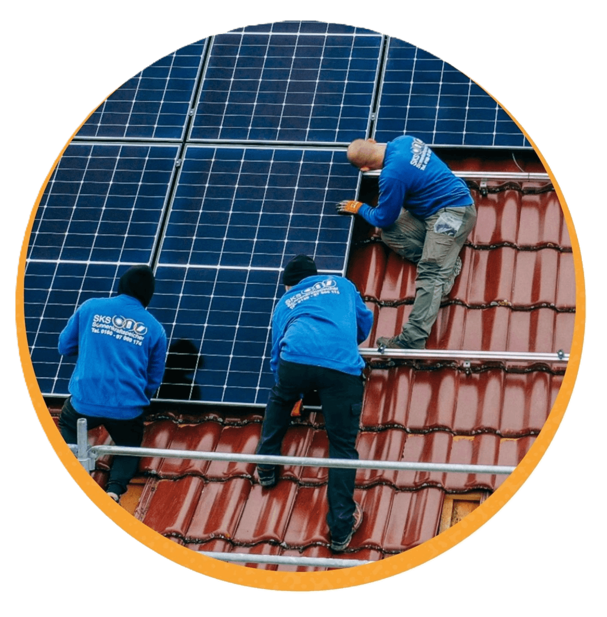 Drei Monteure montieren Photovoltaik-Module auf einem roten Ziegeldach.