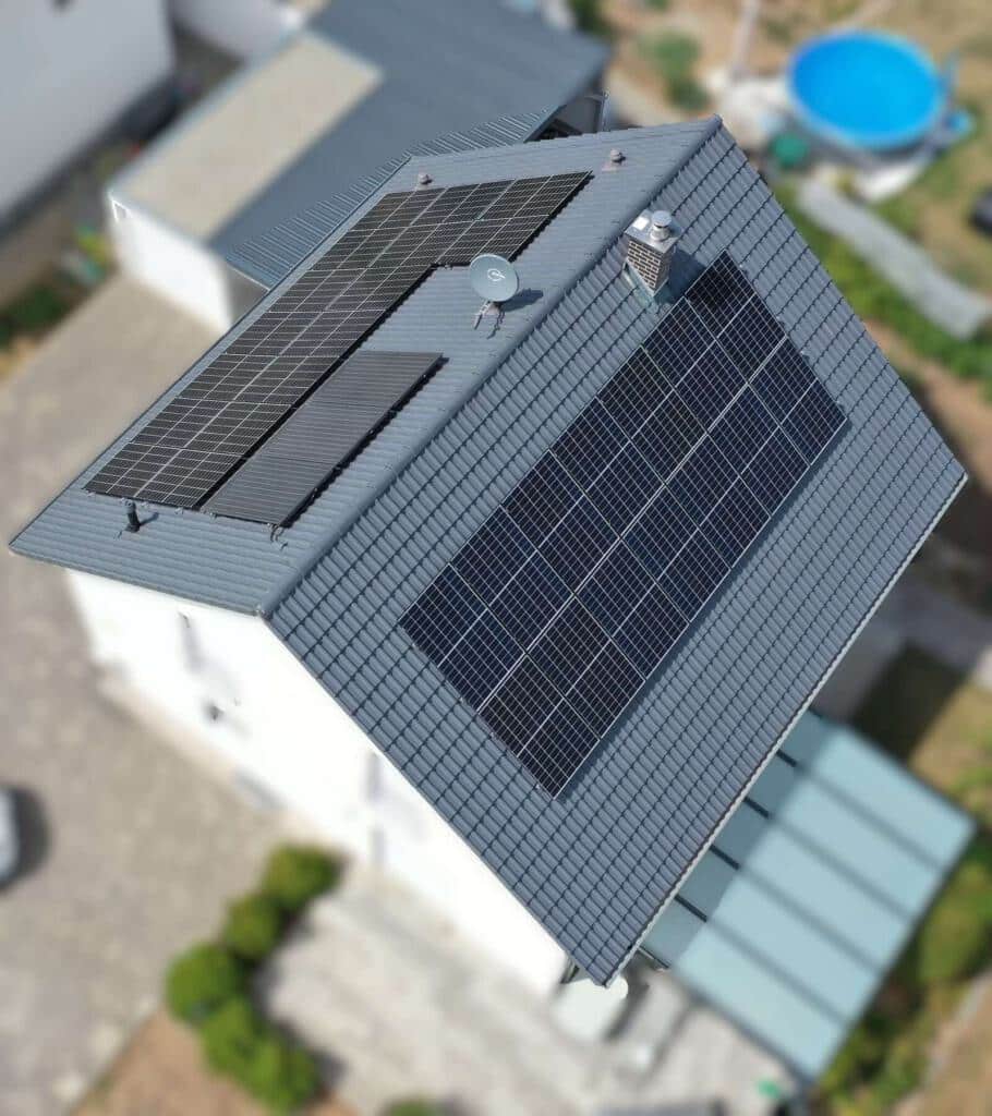Ein Wohnhausdach aus der Vogelperspektive mit montierten Photovoltaikmodulen.